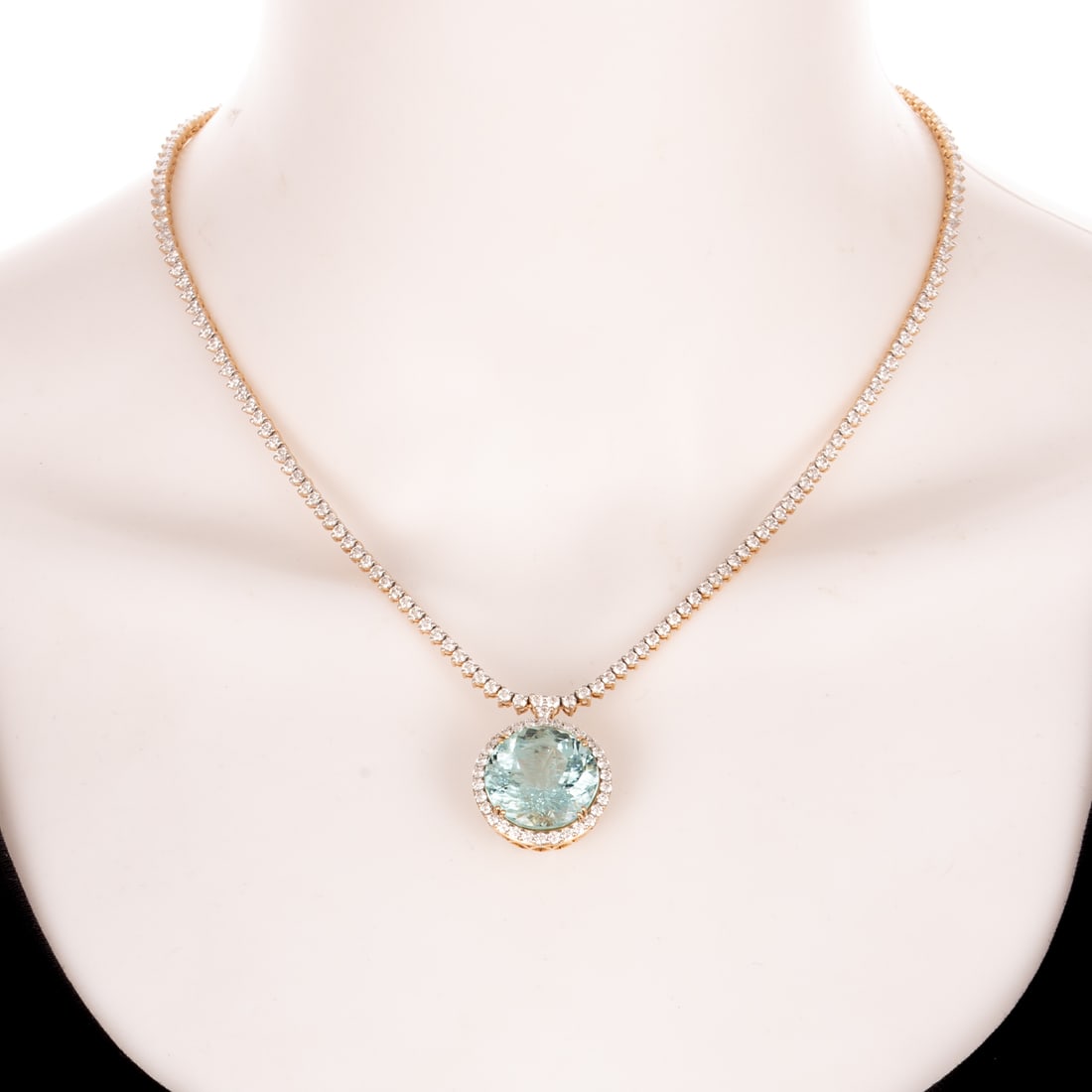 A GIA 19.00 ct Aquamarine & Diamond Line Necklace in 18K: 18K yellow gold necklace by Oscar Friedman featuring a double prong set greenish blue aquamarine weighing 19.00 carats, accompanied by GIA Report #6237415202, surrounded by a halo of shared prong set