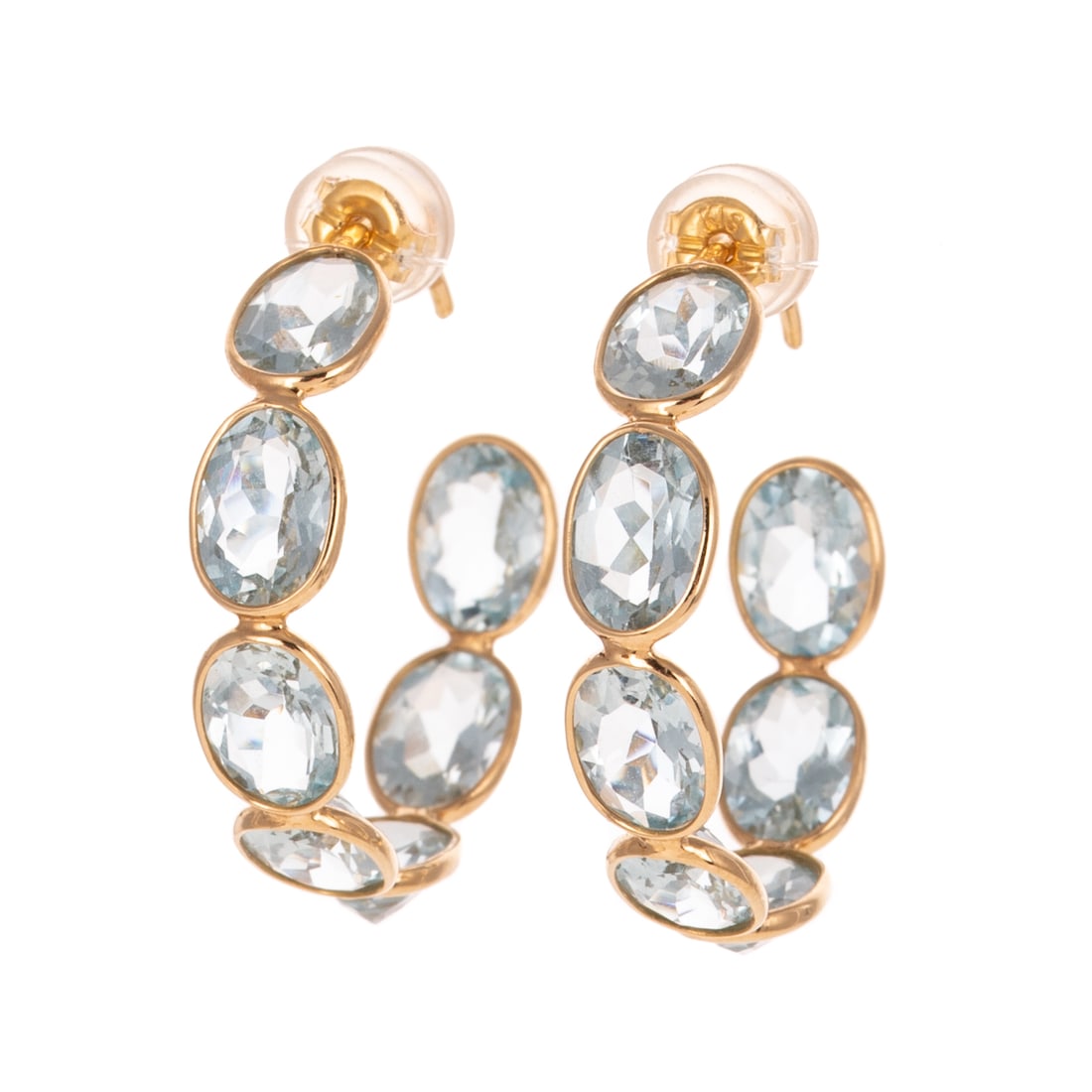 A Pair of Aquamarine Hoops in 18K: 18K yellow gold hoops featuring bezel set oval shaped aquamarines weighing approx. 8.25 ctw, posts with plastic coated friction backs, 1 in. Diam., 3.4 grams
