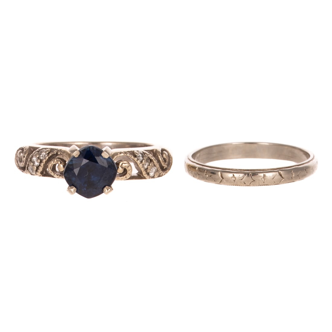 A Sapphire Wedding Set in 14K & 18K: 1) 14K white gold ring featuring a cushion cut sapphire weighing approx. 1.50 carats prong set on an angle with an open swirling design with bead set round diamonds on high polish shank, sz 6.25, and