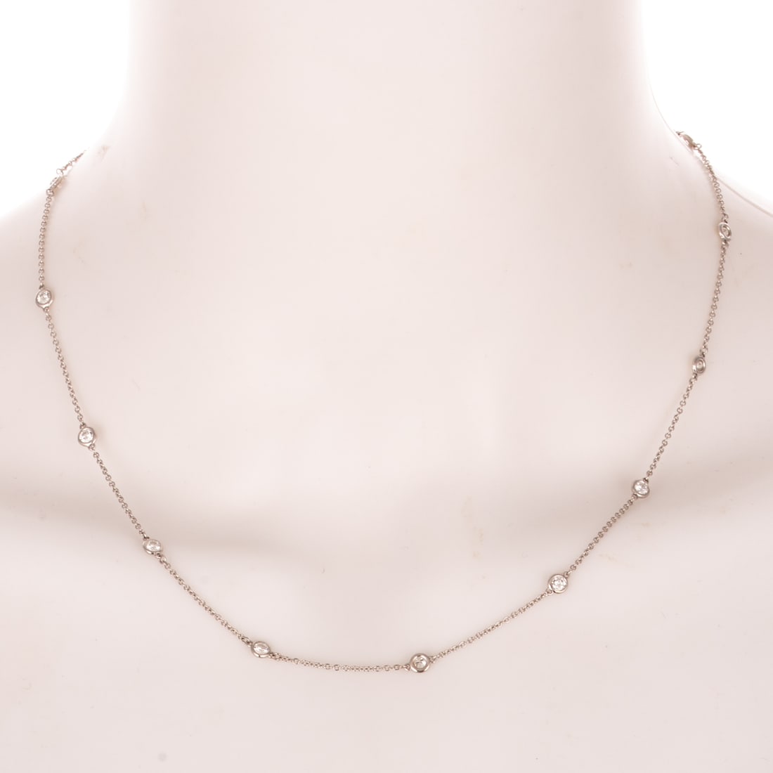 A Diamond Station Necklace in 14K: 14K white gold Italian cable link necklace featuring 11 evenly spaced bezel set diamonds weighing approx. 1.00 ctw with an average color grade of I - J and an average clarity grade of VS - SI, lobster