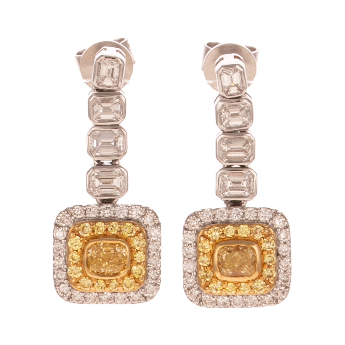 A Pair of Yellow & White Diamond Dangle Earrings in 18K: 18K white gold earrings featuring bezel set cushion cut yellow diamonds surrounded by halos of yellow and white diamonds dangling below a line of slightly graduated bezel set emerald cut diamonds, all
