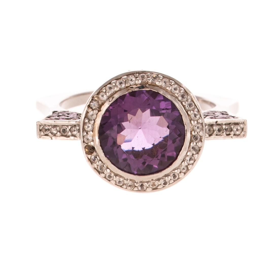 A Contemporary Amethyst & Diamond Ring in 14K: 14K white gold ring featuring a round 10 mm amethyst bezel set in center with diamonds bead set in halo and top of ring with pave set pink sapphires set in sides and gallery of center stone, flared sq