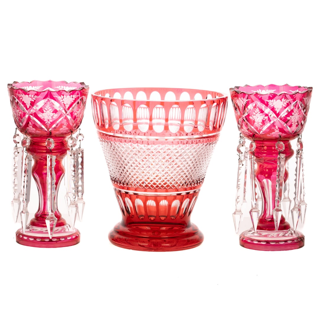 Continental Cranberry Cut-to-Clear Glass Garniture: Late 19th/early 20th century, three pieces, consisting of: a pair of floral engraved lustres and a barrel-form vase, 11 in. H