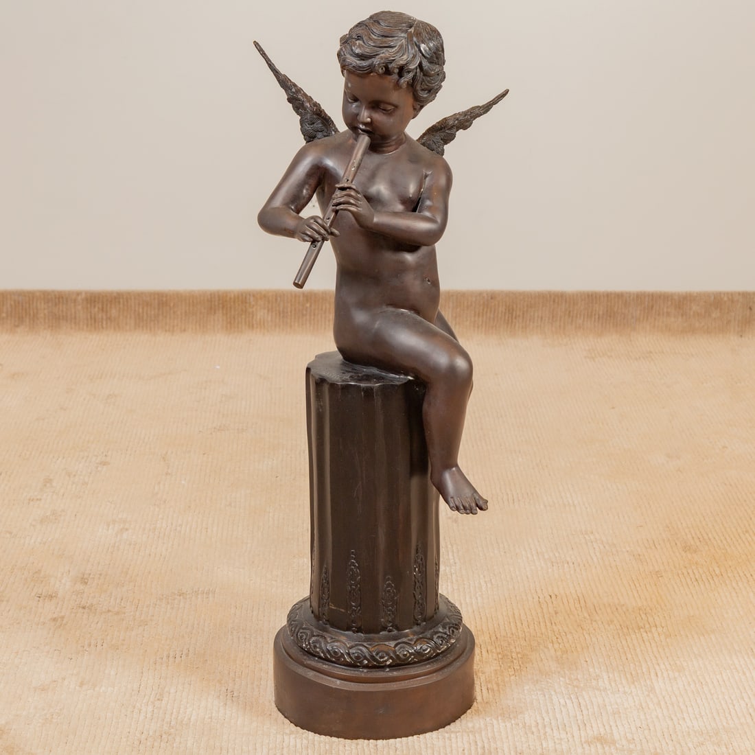 After Giuseppe D'ASTE. Putto Playing Pipe, bronze: Joseph Giuseppe D'ASTE (1881-1945) A patinated bronze of a putto seated on a partial column playing a pipe, signed "J. DASTE" on column, 42 1/2 in. H, 16 in. Diam.