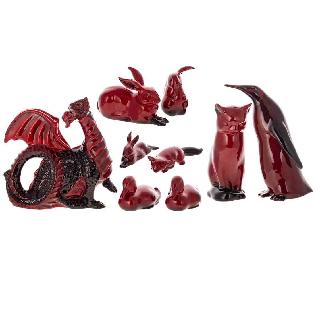 10 Royal Doulton Flambe Glazed Figurines: Consisting of: 'Noke' marked sitting fox, dragon (model 3552), a 6 inch penguin, a sitting cat, two recumbant and one sitting rabbit, a pair of ducks, and a prone fox