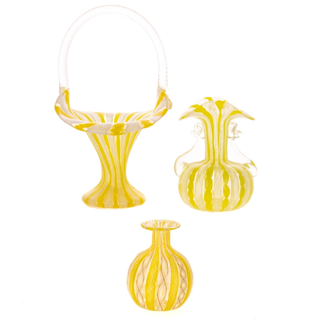 Three Venetian Yellow White Latticino Glass Vases: 20th century, probably Murano, a basket form trumpet vase with lampwork strap handle; a flared, ruffled lip vase with two lampwork side handles; and a bottle vase, 9 in. H