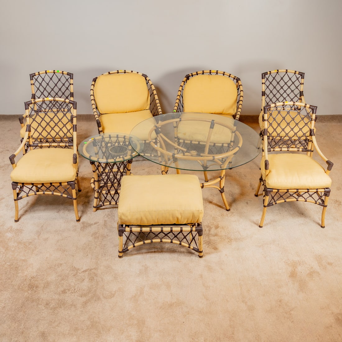 Contemporary Nine Piece Patio Set: Comprising a pair of bamboo and rawhide occasional armchairs: 34 1/2 in. H, 29 in. W, 29 1/2 in. D, four matching armchairs: 38 1/2 in. H, 23 1/2 in. W, 22 in. D, a rectangular hassock, glass top