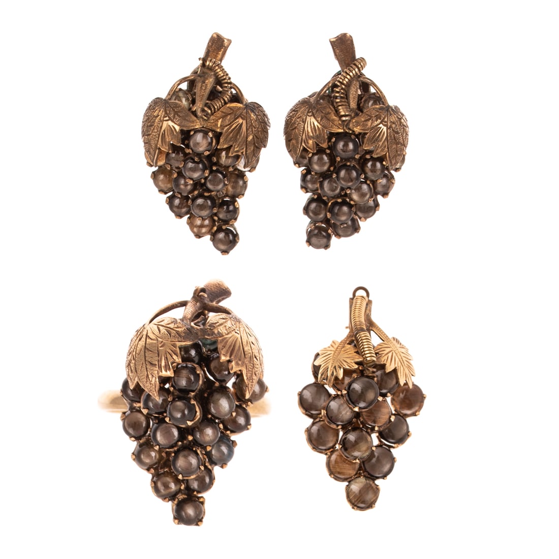 A Suite of Black Star Sapphire Jewelry in 10K: 10K yellow gold suite of jewelry designed as bunches of grapes featuring black star sapphires, ring is sz 7, ear clips measure 1 1/8 in. L, and brooch measures 1 1/2 in. L, 25.2 grams tw