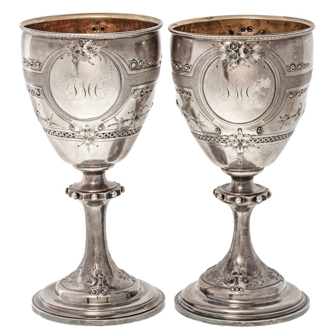 A Pair of Sterling Repousse Goblets: Last quarter 19th century, probably American, unmarked. Stepped circular foot, the stem with bead-trimmed octagonal knop, one side of the bowl featuring a repousse trailing floral bouquet, the reverse