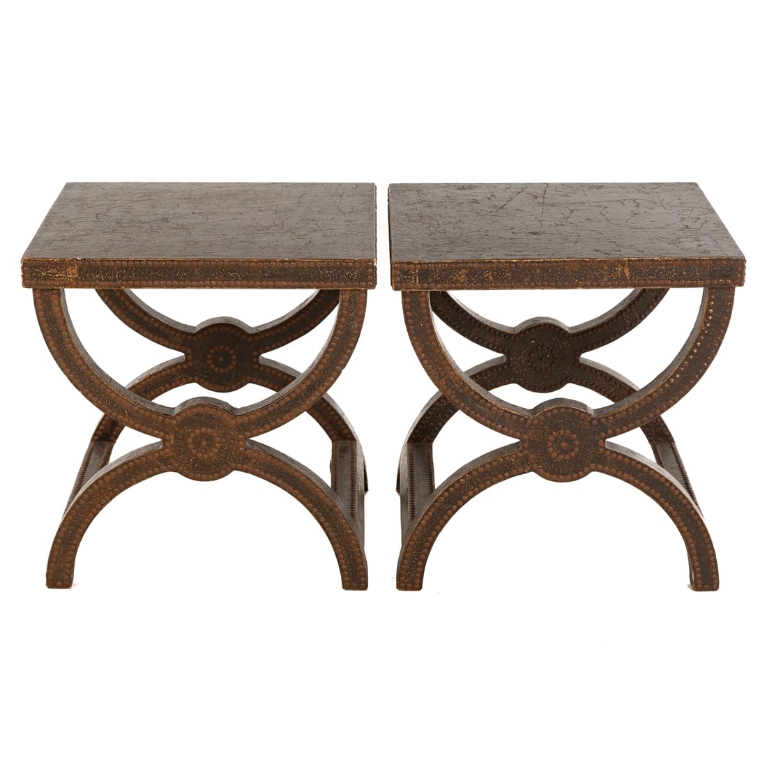 A Pair of Curule Form Faux Leather Wrapped End Tables: Fully distressed faux leather wrapped end tables with hobnail embellishments, 23 in. H, 22 in. W, 20 in. D