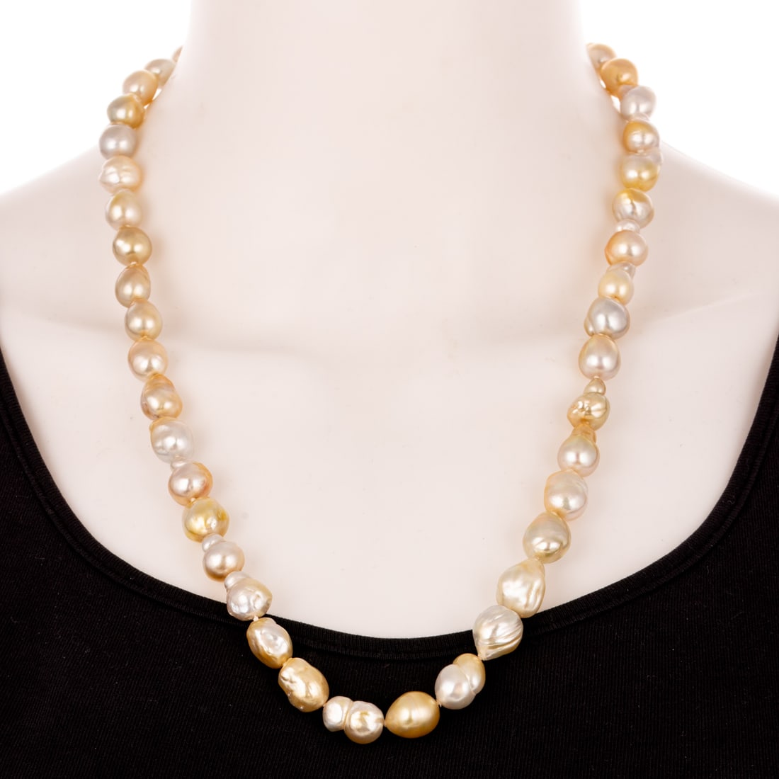 A Strand of Golden & Silver Baroque Pearls: Strand of baroque pearls ranging in size from 9 - 10.5 mm, colors vary in tones from golden, silver and white, 23 in. L, 79.5 grams Provenance: From the collection of Patricia and Joel Siger, from Bal
