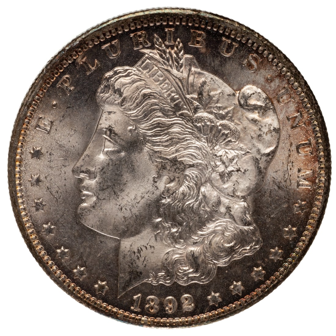 1892-CC Morgan Au58: Reverse has rainbow toning across the bottom edges and natural luster on both sides. Rub and friction is apparent in the hair Provenance: Lifetime numismatic property of a long time Baltimore collecto