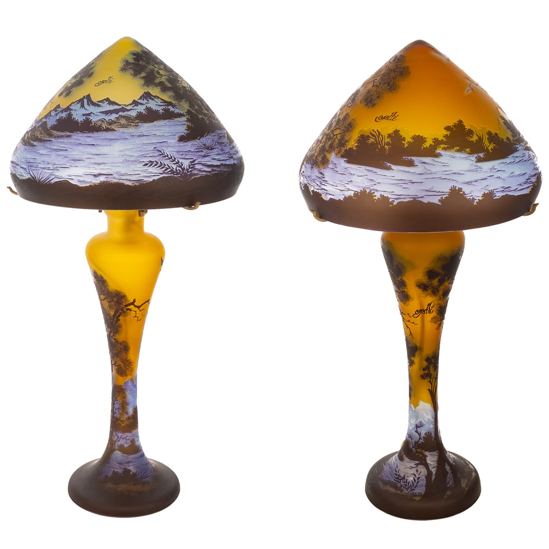 A Pair of Emile Galle Style Table Lamps: A pair of Emile Galle style cameo glass table lamps with landscape scenes on both lamp body and shades, has a double bulb on each with one on the inside of the lamp and under the shade, approx. 25