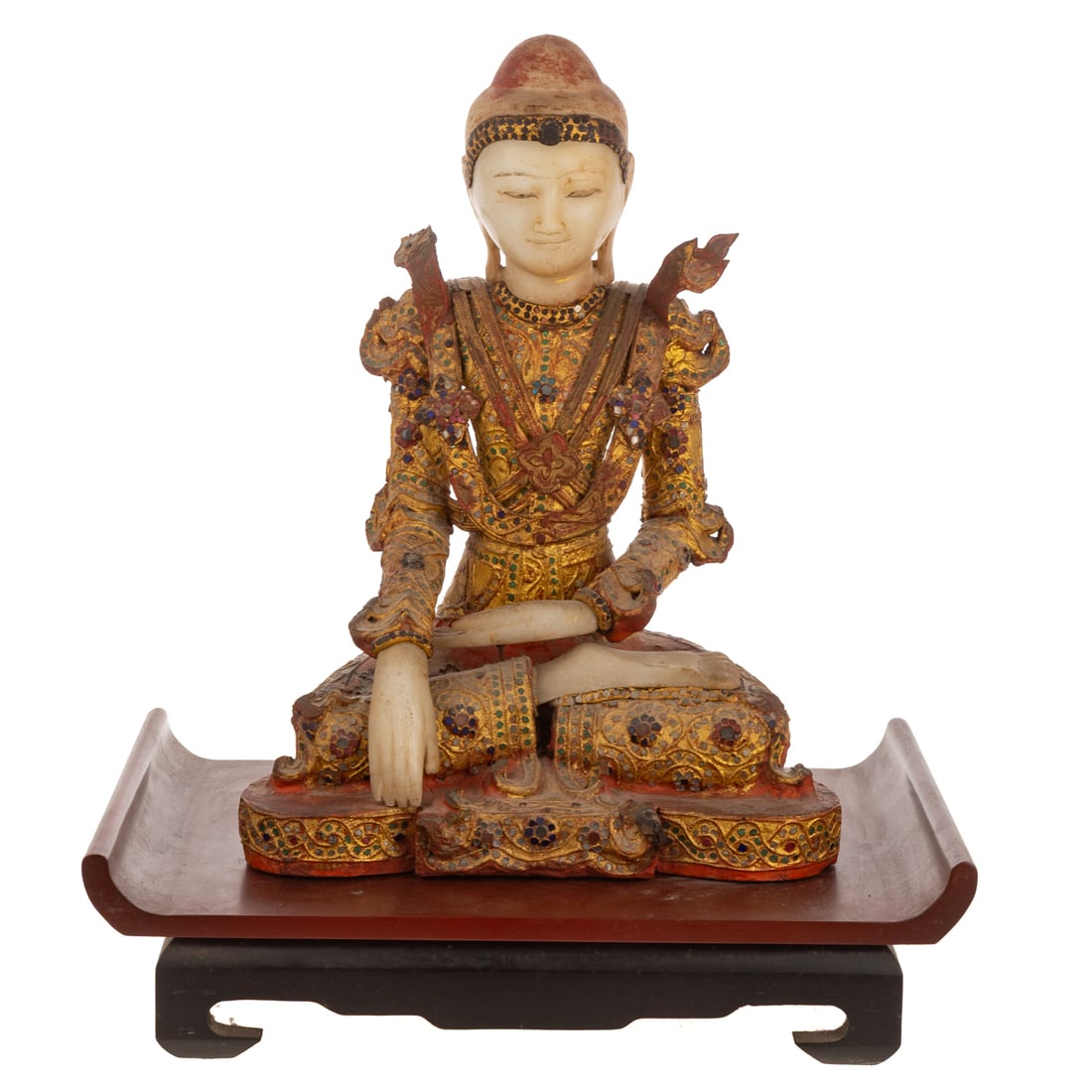 A Burmese Mandalay Buddha: 19th century, an alabaster and wooden Burmese Mandalay seated Buddha in bhumisparsa Mudra, dressed in gilt royal robes adorned with tesserae, includes a red/black wooden stand, 16 1/4 in. H, 12 in.