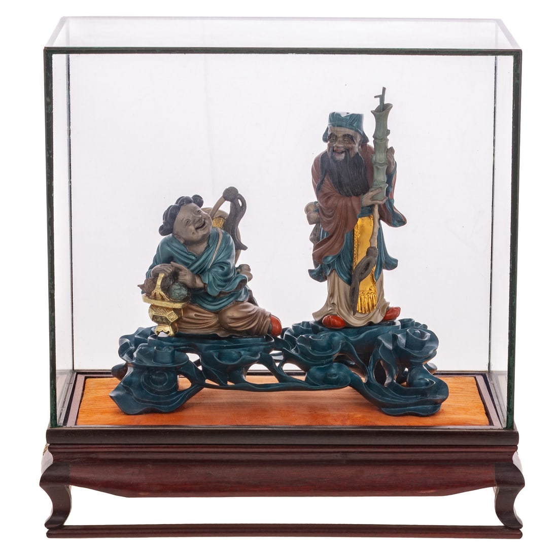 A Chinese Wood & Lacquered Immortal Figural Group: Early 20th century, a carved wood and lacquered figural group affixed to foliage base depicting two immortal figures holding anbaxian "magical treasures" including Zhang Guolao holding a bamboo yugu "