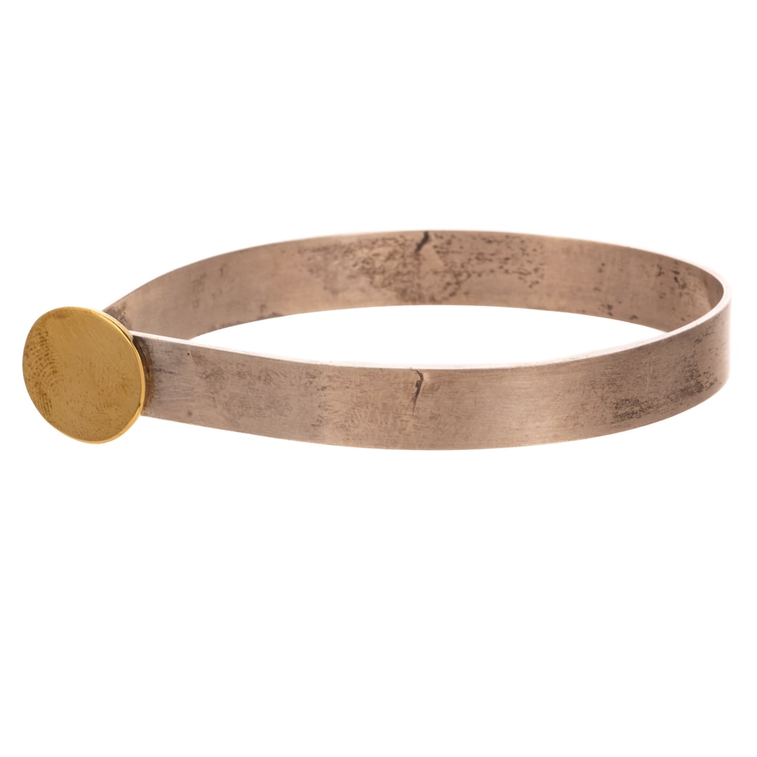A Betty Cooke Two Tone Disc Bracelet in 14K & Sterling Silver: 14K yellow gold and sterling silver bracelet by Betty Cooke (1924 - 2024), Baltimore, MD designed as a high polish flat bracelet with 16 mm 14K yellow gold disc hook clasp set off to one side, signed,