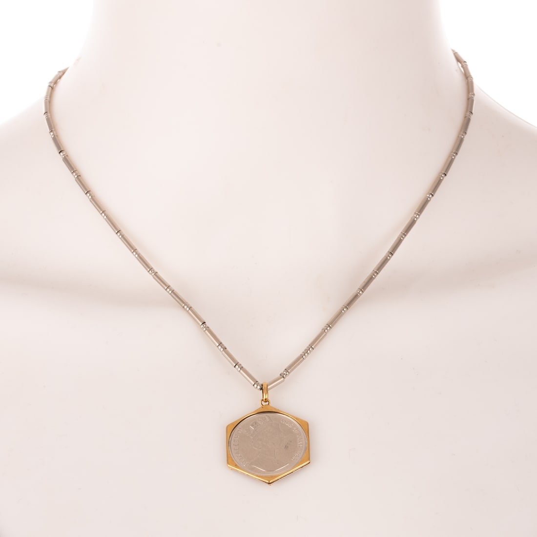 A 1988 Isle of Man 1/4 Noble Coin Pendant on Chain: 1988 Isle of Man 1/4 Noble platinum coin set in a hexagonal 18K yellow gold and platinum bezel, suspended from a platinum chain of evenly spaced tubes and beads, lobster clasp, 17 in. L, 21.4 grams