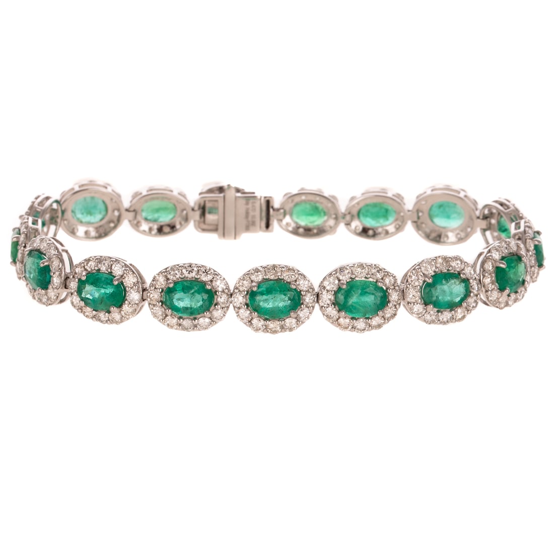 An 10.96 ctw Emerald & Diamond Bracelet in Platinum: Platinum bracelet by Katy Holiday featuring a line of graduated oval shaped emeralds weighing approx. 10.96 ctw individually prong set in the center of round diamond halos shared prong set, all diamon