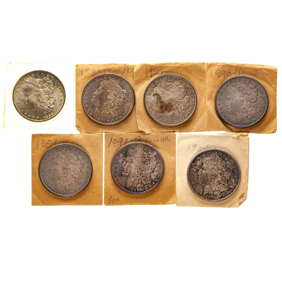 Collection of Seven Silver Dollars, Many Toned: Six are in old envelopes and 1 (1885-O) is in a plastic case; 1885-O Choice AU with beautiful gold toning on Reverse; 1904-O AU with lustrous envelope toning; 1921 with semi PL colorful toning, 1899-O