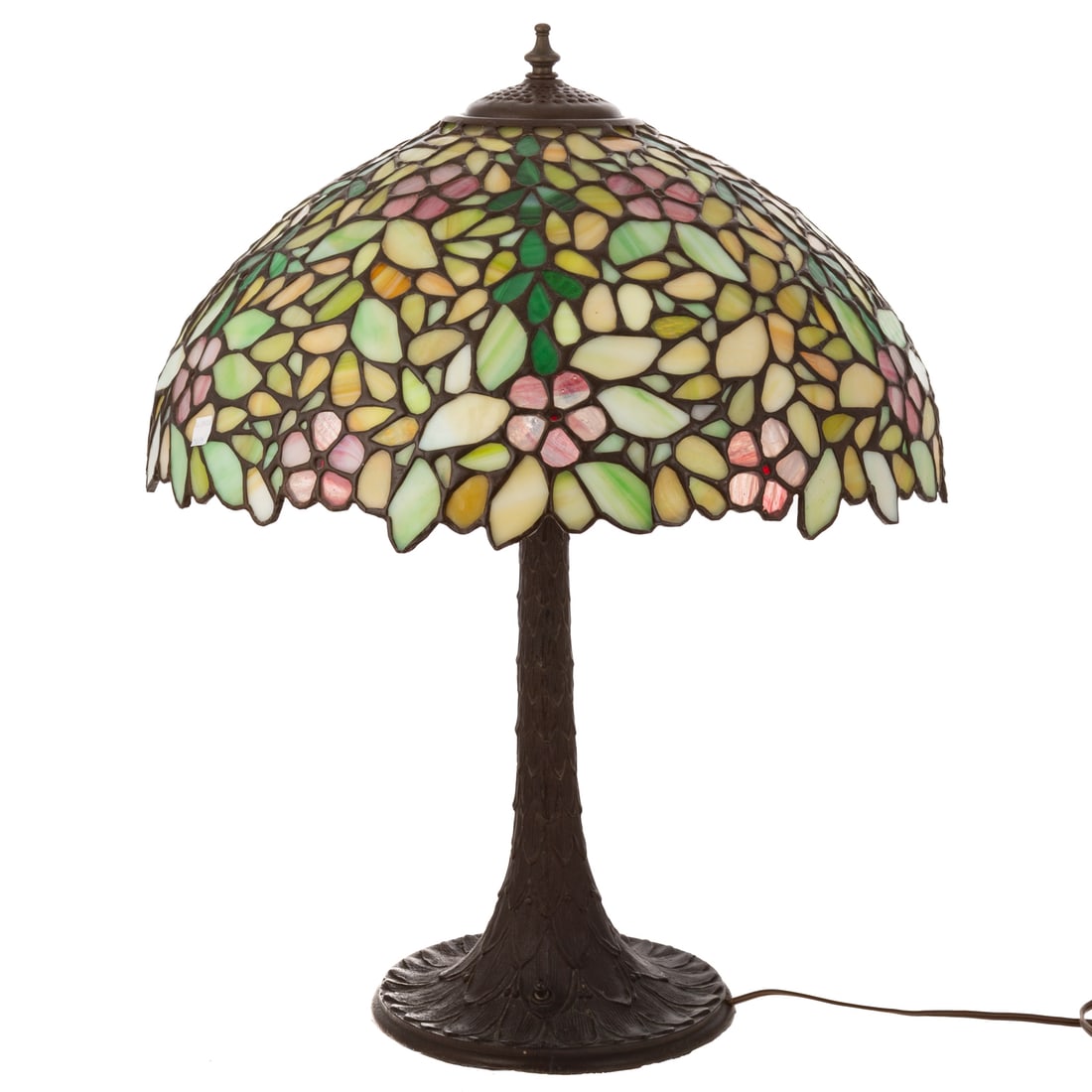 A Tiffany Style Stained Glass Lamp: A Tiffany style stained glass lamp with floral decorated shade and a feathered patented bronze base, unmarked, 23 1/4 in. H, 8 3/4 in. Diam., shade: 8 3/4 in. H, 18 1/4 in. Diam.