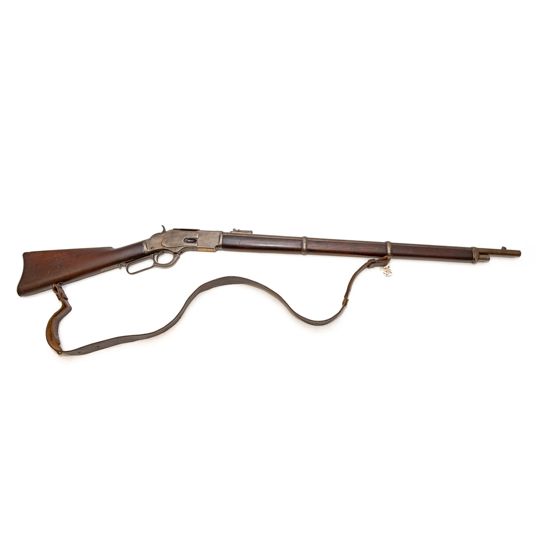 A Winchester Repeating Arms Model 1873 Rifle: Circa 1891; serial number 370462B, marked behind lever; .44 caliber centerfire, marked on the brass loading hatch and on top of barrel; the barrel, 30 in. L; leather shoulder strap of the period; the 