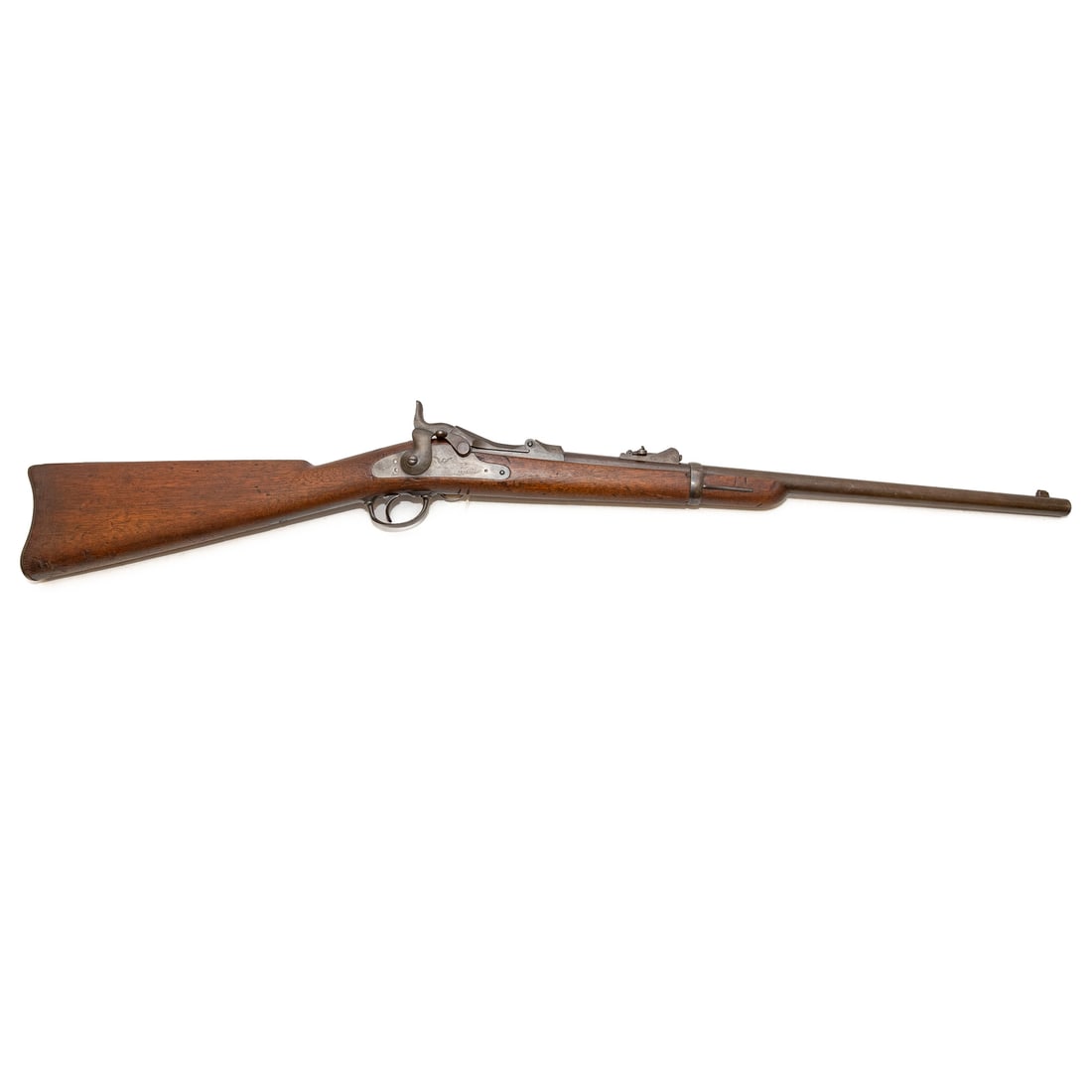 A Springfield Model 1873 Trapdoor Carbine Rifle: Serial number 182433 and a star marked at rear of breech; .45/70 caliber; the barrel, 22 in. L; graduated ladder rear sight with slotless screws and blade lug front sight; cleaning rods in butt stock;