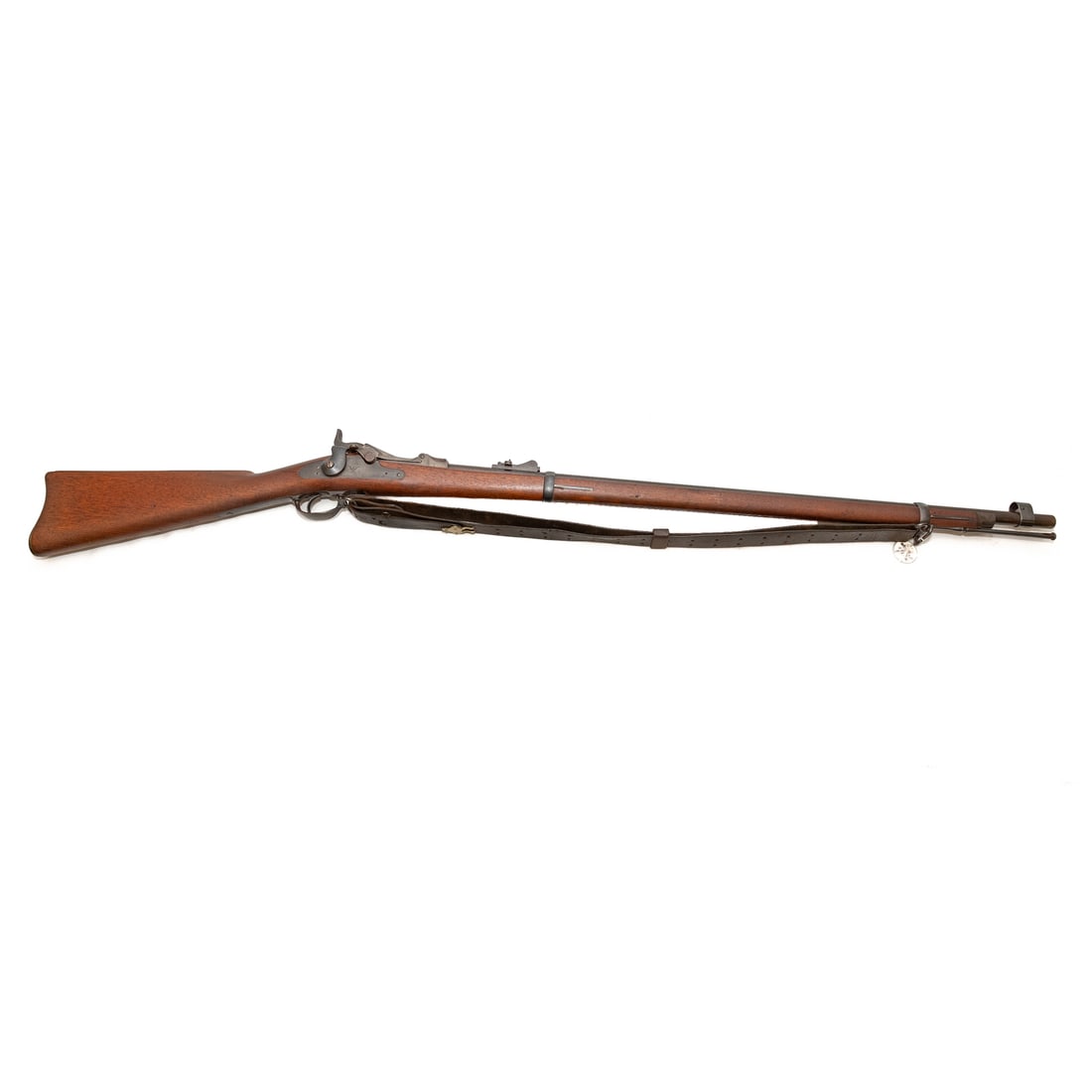 A Springfield Model 1873 Trapdoor Rifle: Serial number 216775, marked on top of receiver; .45/70 caliber; the barrel, 32 1/2 in. L; leather shoulder strap of the period; marked on lock plate "U.S. Springfield," with American eagle; the