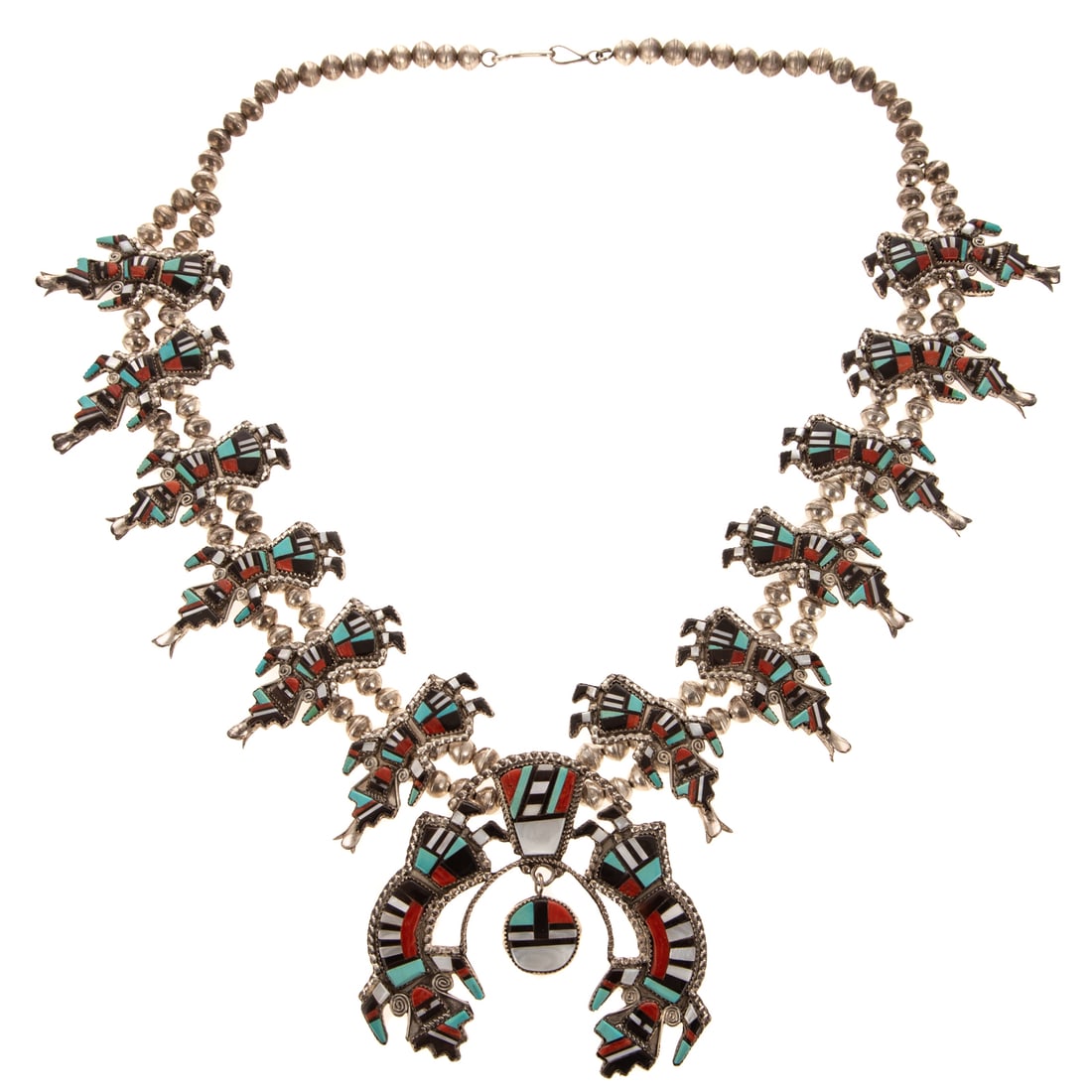A Herbert & Esther Cellicion Rainbow Man Squash Blossom Necklace in Silver: Silver inlaid Rainbow Man squash blossom necklace by Zuni artists Herbert and Esther Cellicion, with inlaid gemstones including turquoise, coral, Mother of Pearl, and jet, with a double Rainbow Man Na