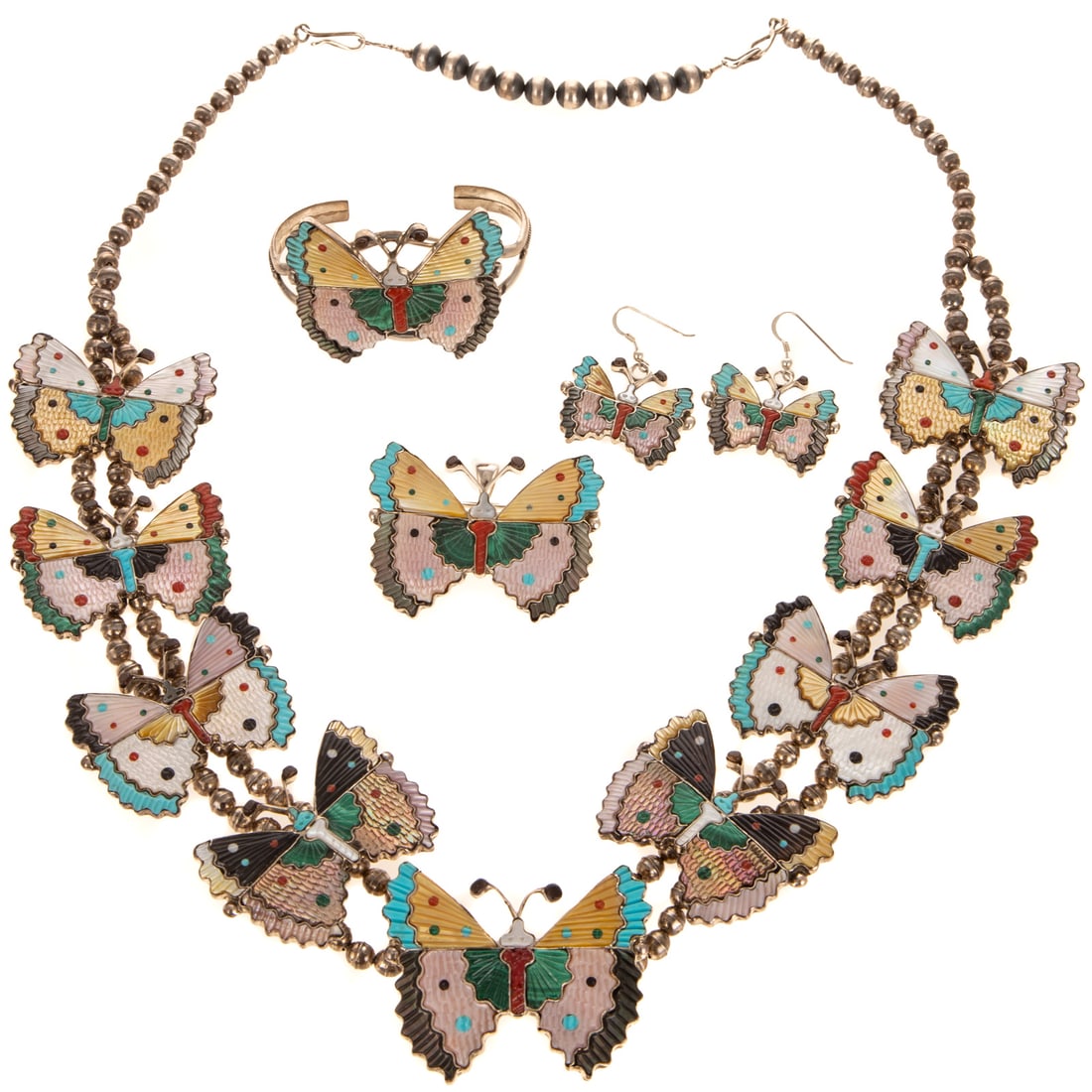 A Zuni Inlaid Butterfly Suite by Tamara Pinto in Sterling Silver: Early 20th century, sterling silver butterfly inlaid gemstone suite by Zuni artist Tamara Pinto, suite includes necklace, cuff bracelet, brooch/pendant, and earrings, hand carved inlaid gemstones incl