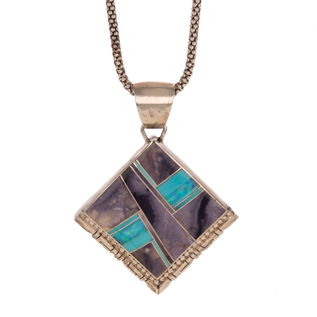 A Signed Navajo Pendant & Chain in Sterling Silver: Sterling silver Navajo pendant featuring inlaid gemstones including turquoise, opal, and charoite, signed "ATB," 1 1/2 in. L, hanging on sterling silver popcorn chain with spring ring clasp, 19 in. L,