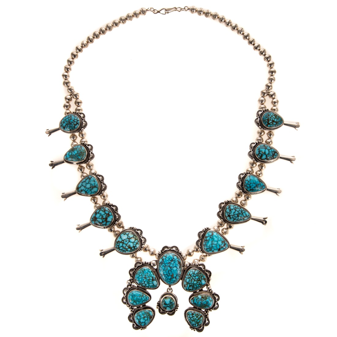 A Thomas Francisco Turquoise Squash Blossom: Sterling silver squash blossom necklace by Navajo designer Thomas Francisco featuring turquoise set large Naja and squash blossoms, Naja measuring 3 1/2 in. W, hook clasp, 28 in. L, signed, 259.9 gram