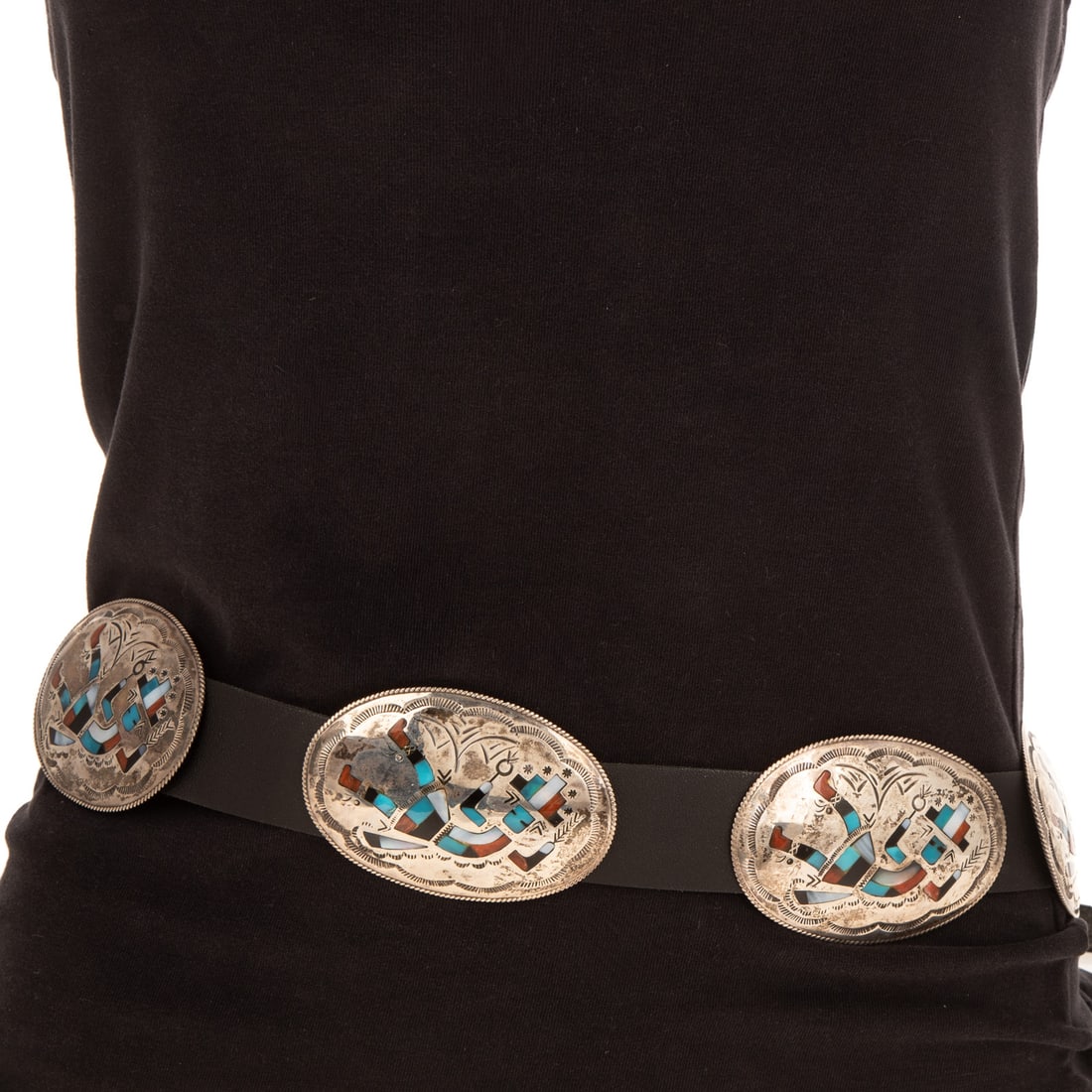 A Benjamin Bacenti Rainbow Man Concho Belt in Sterling Silver: Sterling silver Rainbow Man concho belt by Navajo artist Benjamin Bacenti (b. 1950), featuring inlaid gemstones including turquoise, Mother of Pearl, coral, and black onyx, creating the arching Rainbo