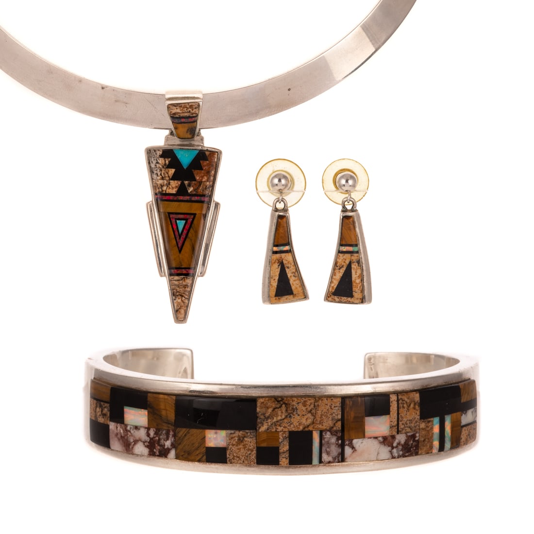 A Native American Suite of Inlay Jewelry in Sterling Silver: Sterling silver necklace, cuff and dangle earring near matching suite by Navajo artists including Calvin Begay, Olson Charleston and Rick Tolino, featuring high polish tiger's eye, picture jasper, ony
