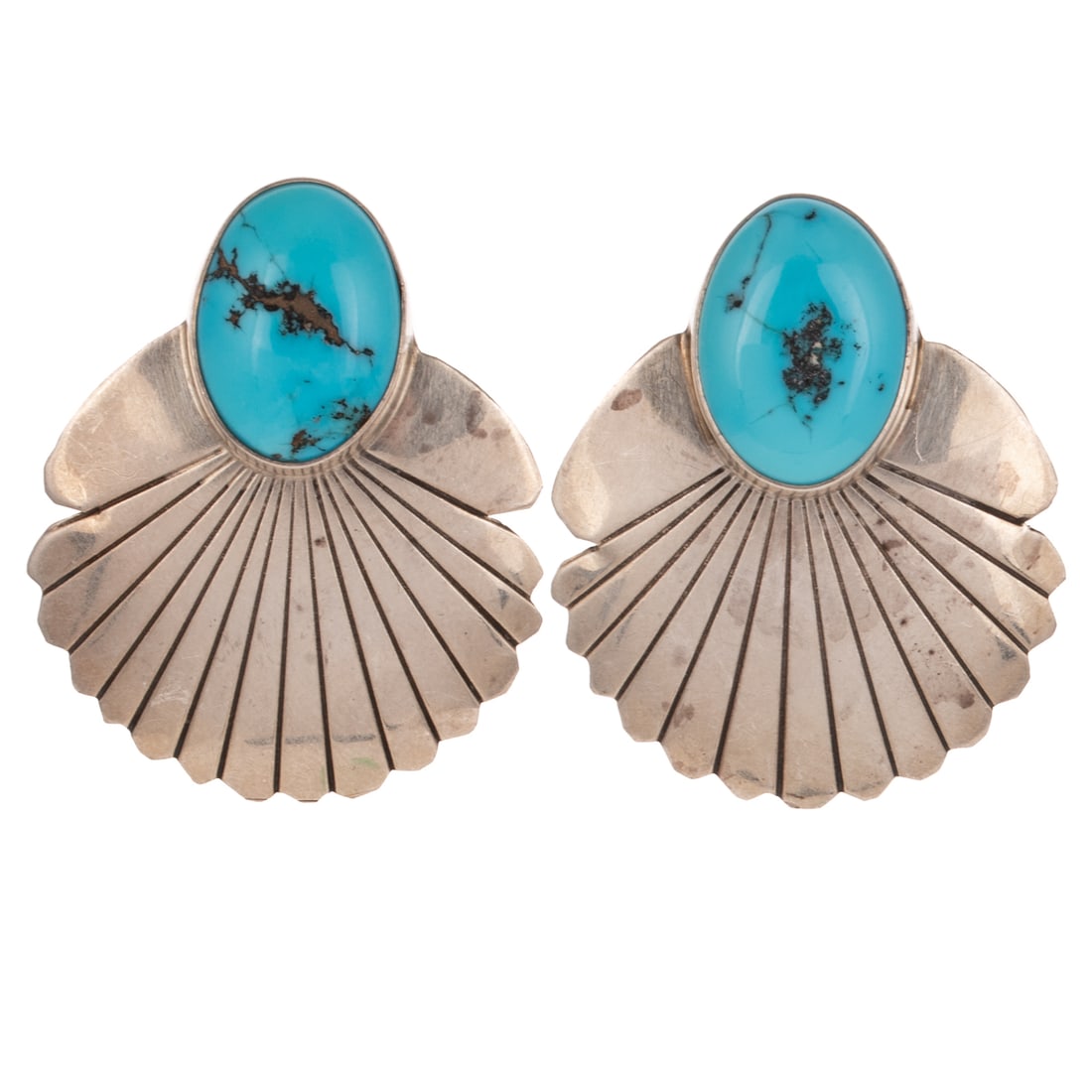 A Pair of Navajo Turquoise Earrings in Sterling Silver: Sterling silver Navajo earrings with bezel set turquoise with exposed matrix, engraved fan design, posts with friction backs, 1 3/8 in. L, 13.3 grams Provenance: From a private collection, Doylestown,