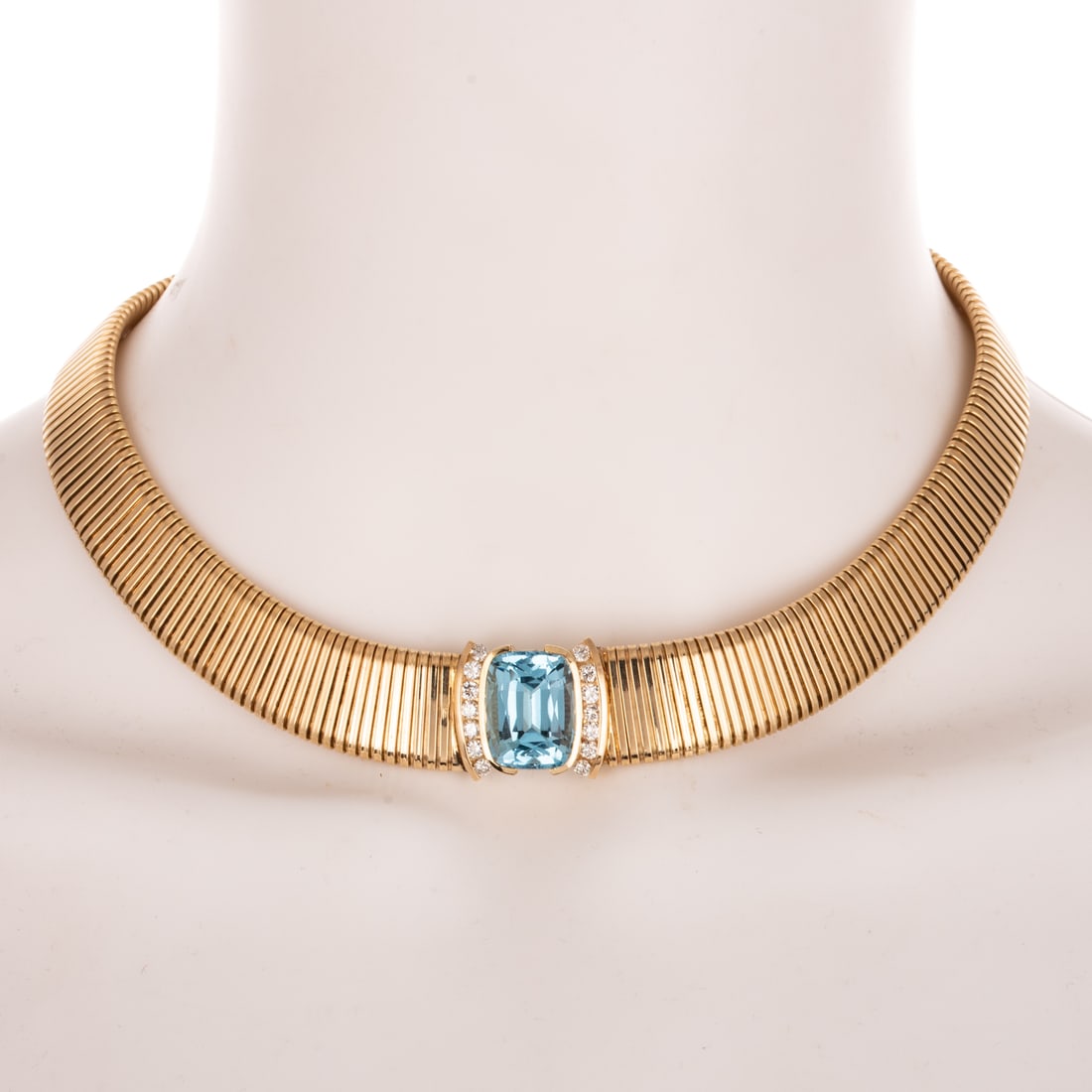 An Italian Blue Topaz Goose Neck Necklace in 14K: 14K yellow gold Italian tapered goose neck necklace featuring a cushion cut blue topaz weighing approx. 15.00 ctw bezel set between two conforming columns of round diamonds weighing approx. 1.50 ctw