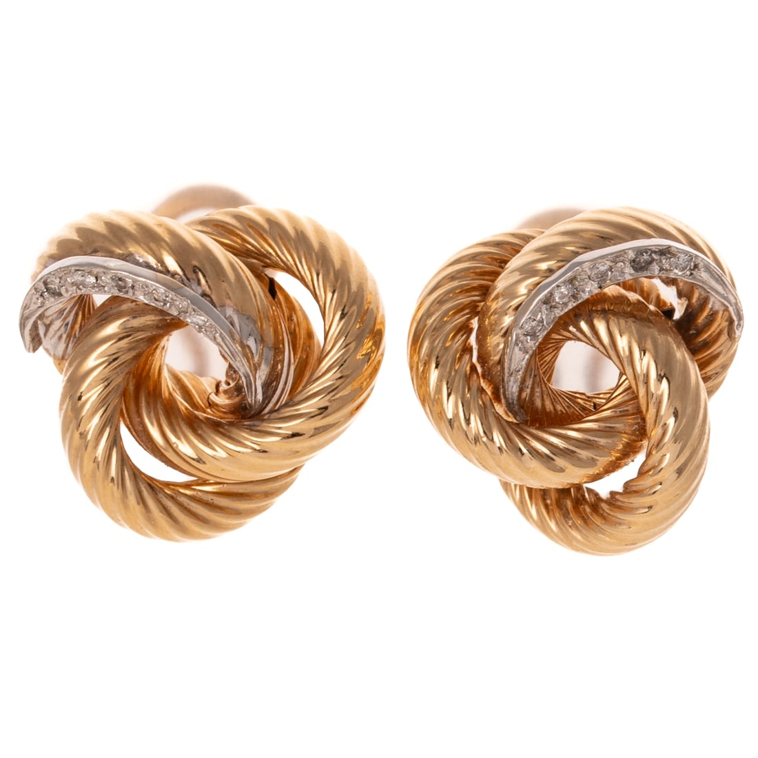 A Pair of Diamond Knot Ear Clips in 14K: 14K yellow gold ear clips featuring large textured knots with a crescent shaped white gold panel featuring round diamonds bead set, Omega backs, 3/4 in. Diam., 7.6 grams