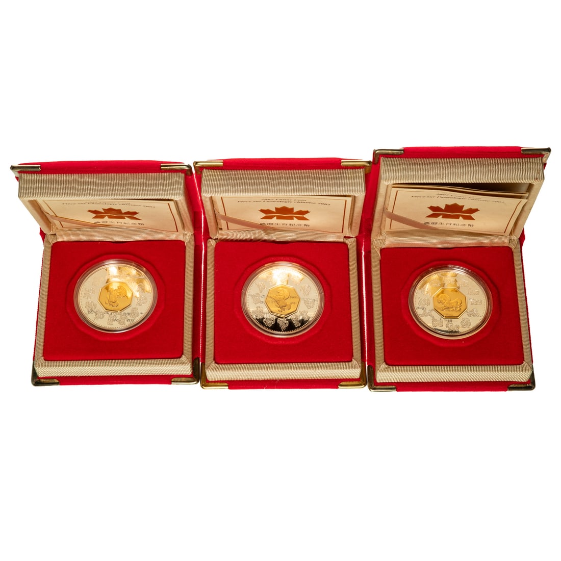 Three - 2002 Lunar Coins Royal Canadian Mint: They are packaged like a little book that opens to a COA on the left and the coin on the right. The obverse is Queen Elizabeth II and the reverse is a sterling silver coin that features the Year of