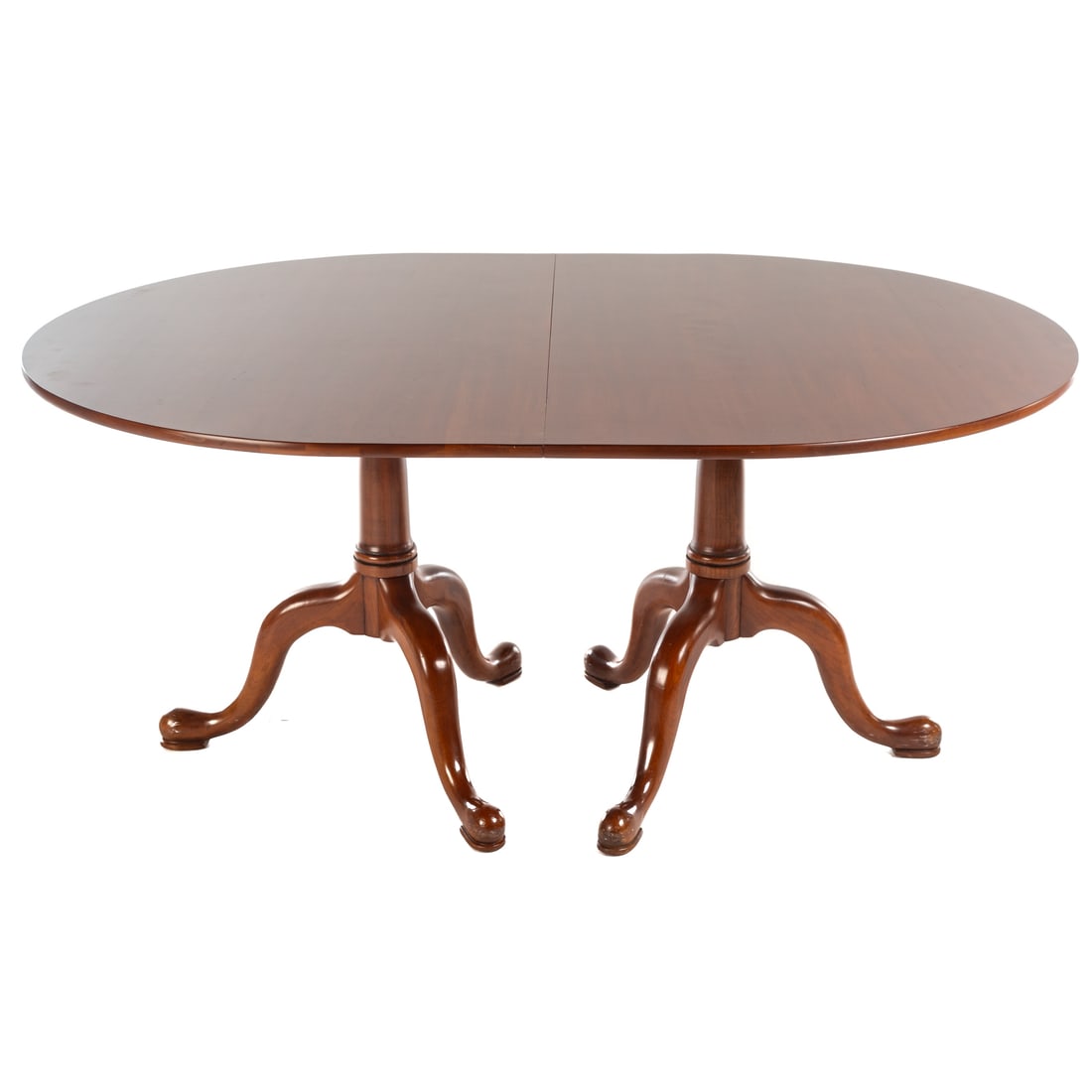Henkel Harris Cherry Pedestal Dining Table: Curved end and apronless top supported by double turned pedestals extending into tripod legs ending in serpentine feet, 30 in. H, 66 in. W, 48 in. D, with four 12 in. extension leaves