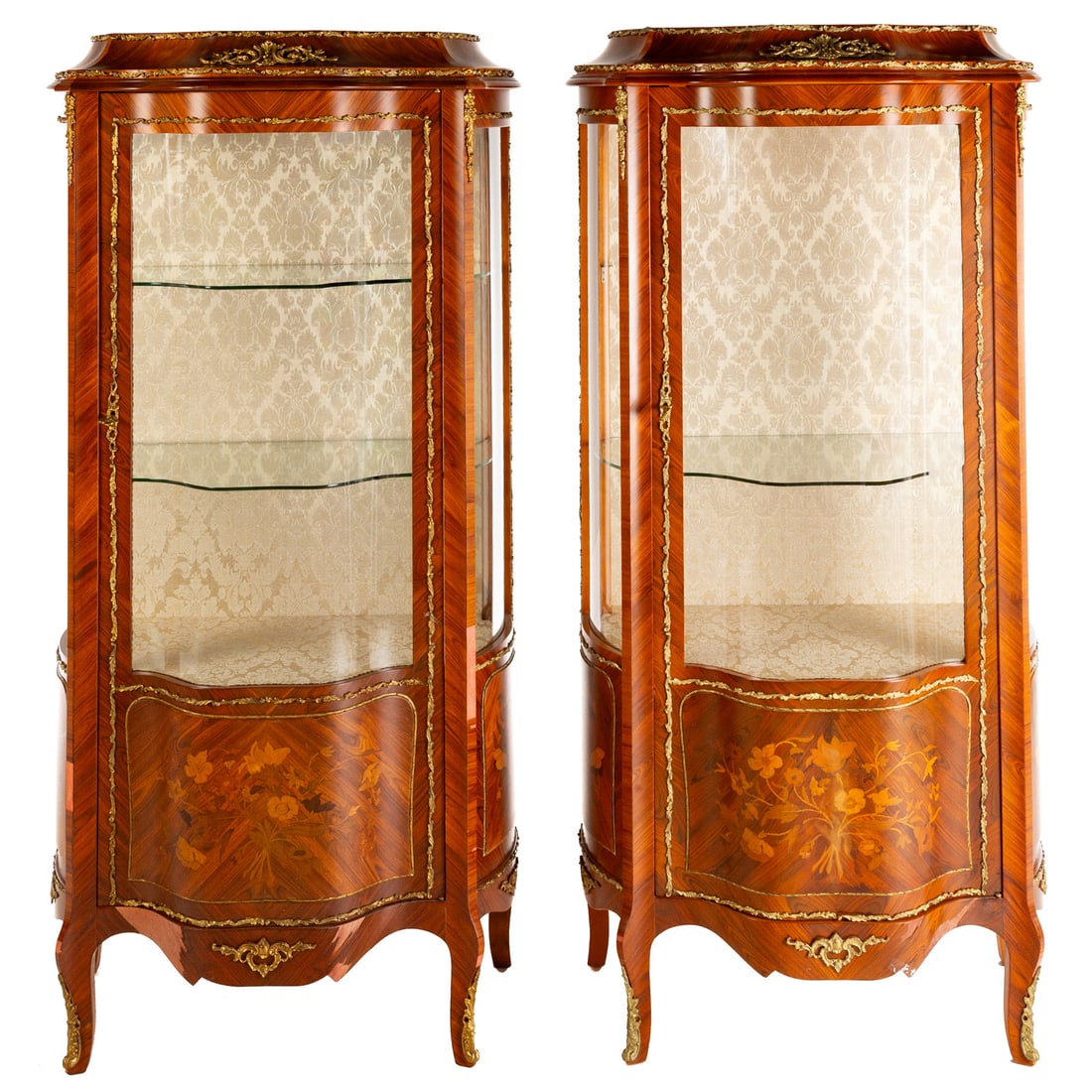 A Pair of Louis XV Style Marquetry Inlaid Vitrines: A pair of kingwood and tulipwood marquetry and parquetry ormolu mounted one door shaped vitrine cabinets, each: 62 1/2 in. H, 31 1/2 in. W, 19 in. D
