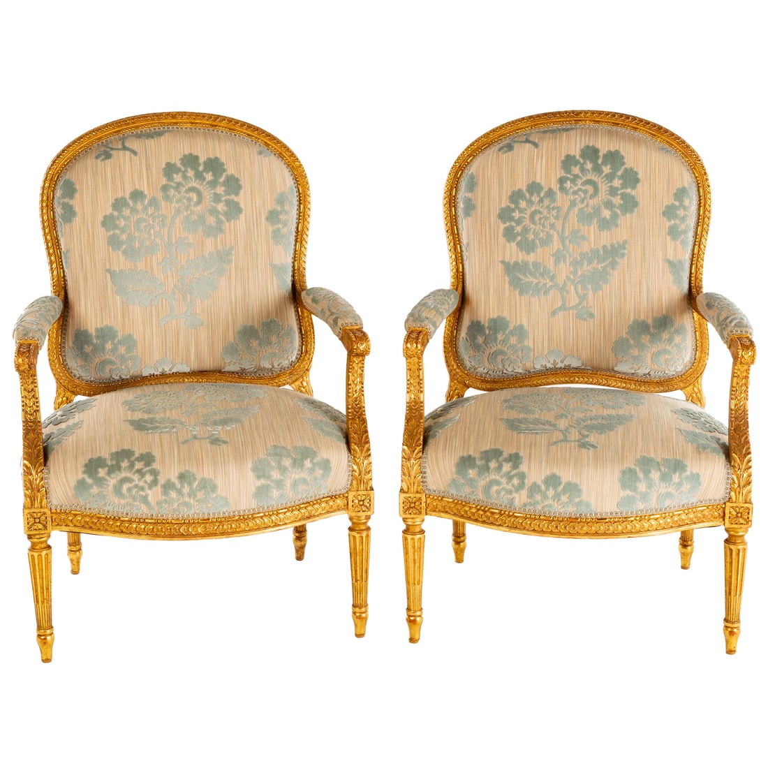 A Pair of Louis XVI Style Giltwood Fauteuils: Carved and gilt frames with upholstered backs, seats and arms, ending in turned and tapered stop fluted legs, each: 39 1/2 in. H, 27 1/2 in. W, 21 in. D