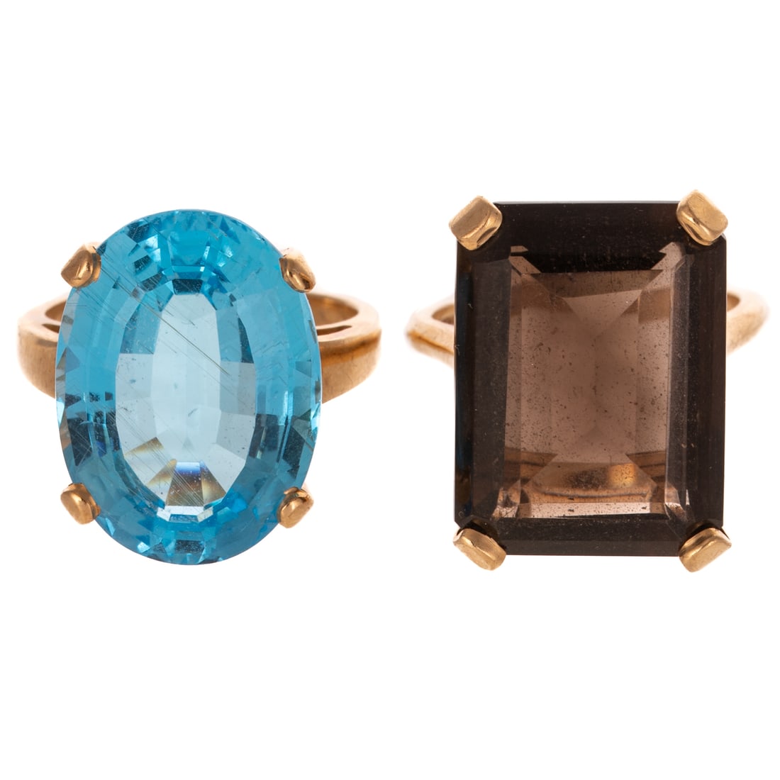 A Large Blue Topaz & Amethyst Ring in 14K: 1) 14K yellow gold ring featuring an oval blue topaz measuring 15 x 20 mm, sz 8, and 2) 14K yellow gold ring featuring an emerald cut smoky quartz measuring 15 x 20 mm, sz 8, 20.3 grams tw Provenance: