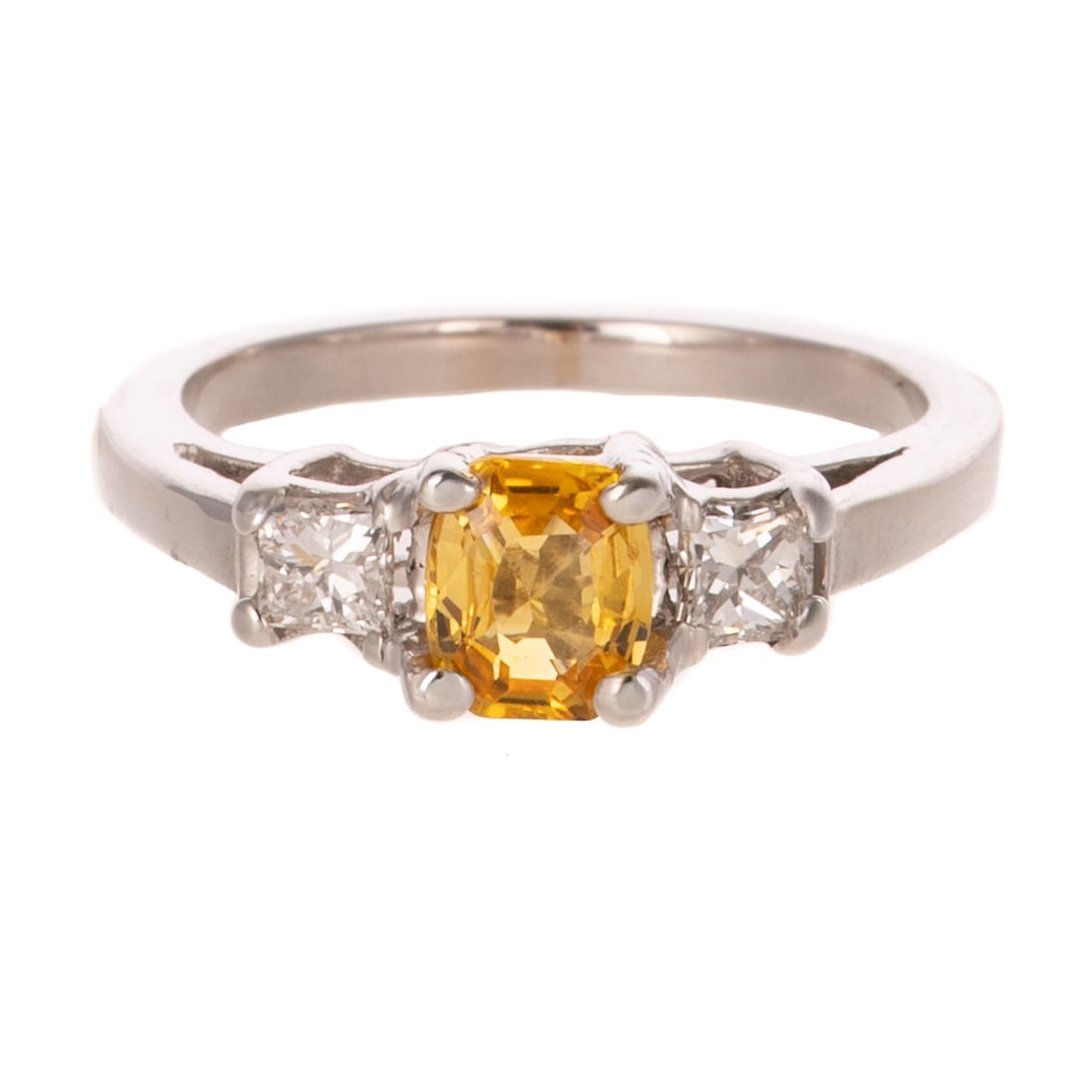 A Yellow Sapphire & Diamond Ring in 18K: 18K white gold ring featuring a cushion cut yellow sapphire weighing approx. 1.20 cts prong set between two princess cut diamonds weighing approx. 0.30 ctw with an average color grade of I - J and an 