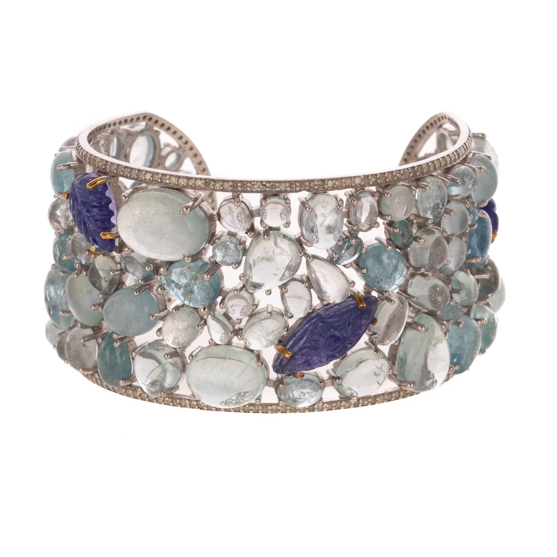 An Aquamarine & Tanzanite Tutti Frutti-Style Cuff: Sterling silver cuff featuring mixed-shaped aquamarine cabochons weighing approx. 117.00 carats and carved tanzanite cabochons weighing approx. 21.00 carats prong set in a Tutti Frutti style, all outl