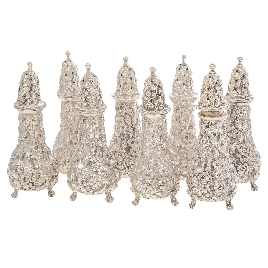 Eight Stieff Sterling Repousse Pepper Casters: Model# 12, with various date marks. Each with floral and foliate repousse decoration, against a stippled ground, raised on three scrolling feet, with assorted monograms, 4 3/8 in. H, 15.6 ozt.