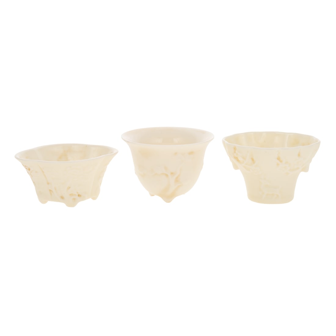 Three Chinese Blanc-de-Chine Libation Cups: Three blanc-de-chine Chinese porcelain libation cups. Includes a tri-footed Chinese blanc-de-chine libation cup depicting blossoming prunus with flared rim, 1 3/4 in. H, 2 3/4 in. Diam.; a Chinese bla