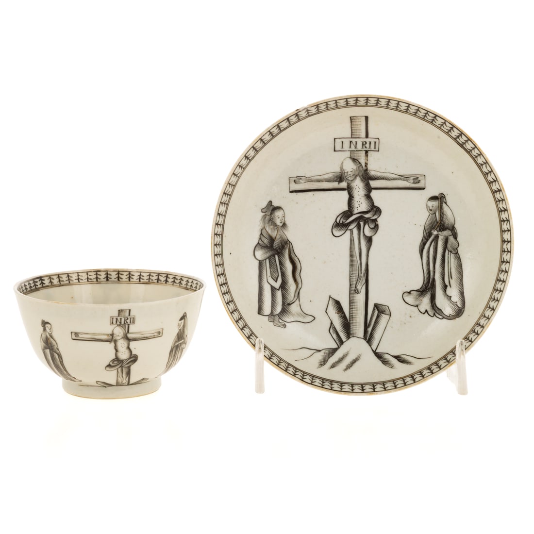 Chinese Export En Grisaille Porcelain Cup & Saucer: A porcelain Chinese Export En Grisaille cup and saucer depicting the crucifixion with Christ on the cross and two figures on either side, cup: 1 3/4 in. H, 3 1/4 in. Diam., saucer: 1 1/4 in. H, 5 in. 