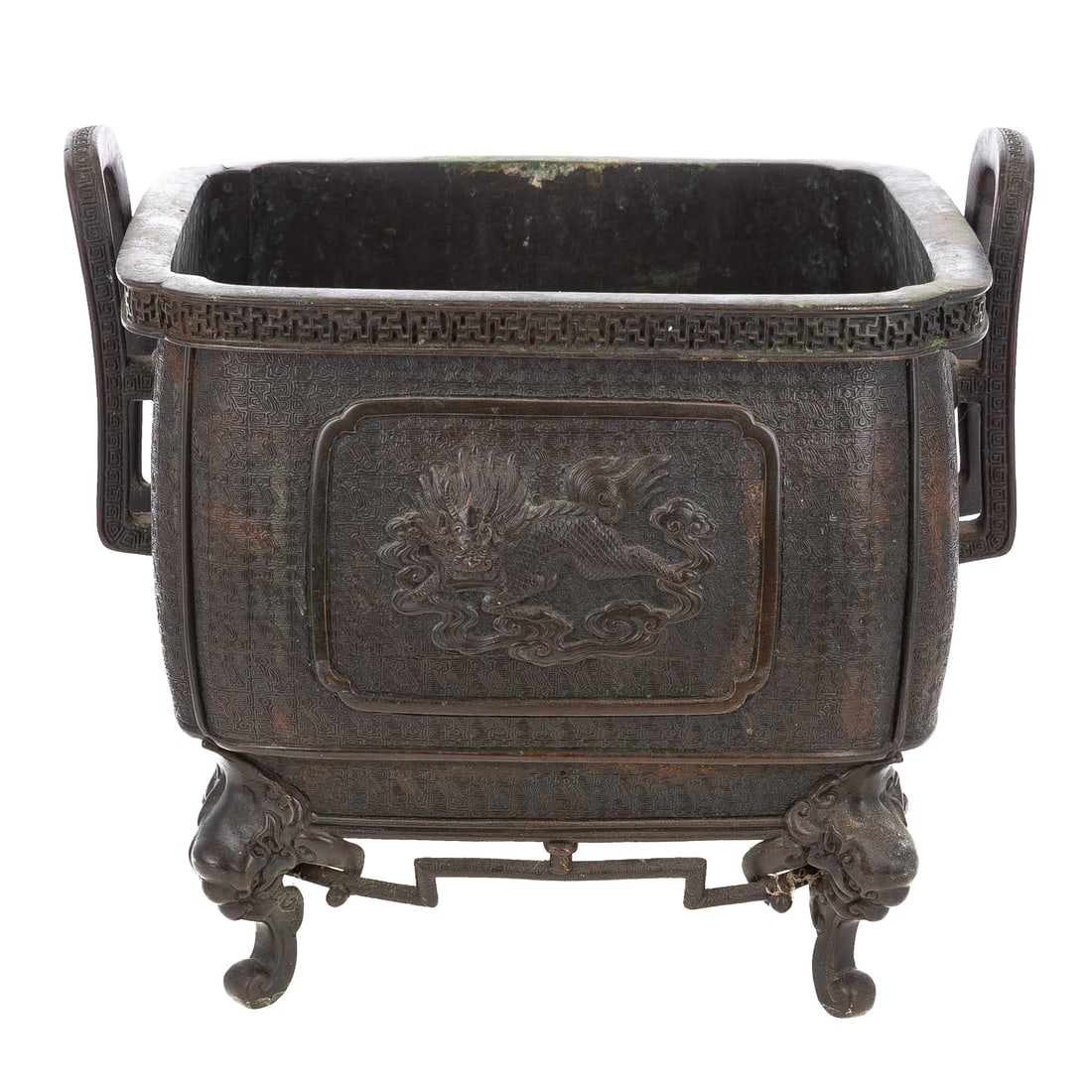 A Chinese Bronze Footed Censer: A bronze Chinese footed censer with side handles and raised relief decoration of a phoenix on one side and dragon on the other, four feet emerging from the mouth of foo dogs, interior removable base p