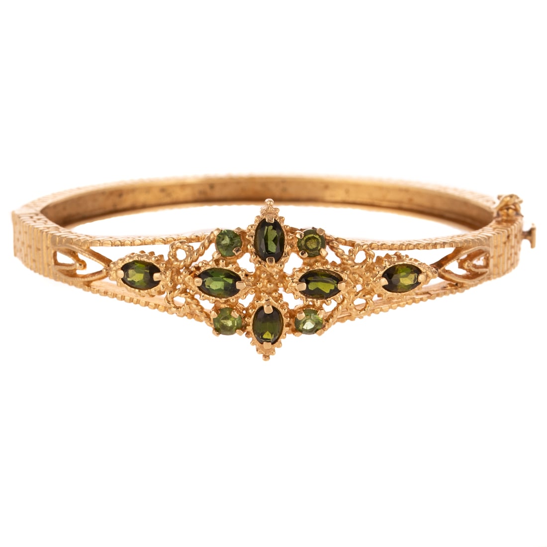 A Green Tourmaline & Peridot Bangle in 14K: Victorian Revival 14K yellow gold oval hinged bangle featuring marquise green tourmalines and round peridot prong set in floral design in center of tapered bangle, etched ridge design throughout