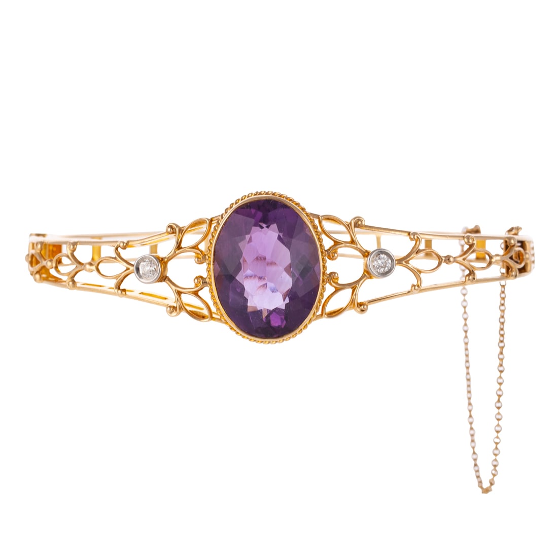A Victorian Amethyst & Diamond Bangle in 14K: c.1880s 14K yellow gold oval hinged bangle bracelet featuring a large oval faceted amethyst measuring 14 x 18 mm, bezel set with twist rope frame, diamonds weighing approx. 0.10 ctw are set within ope