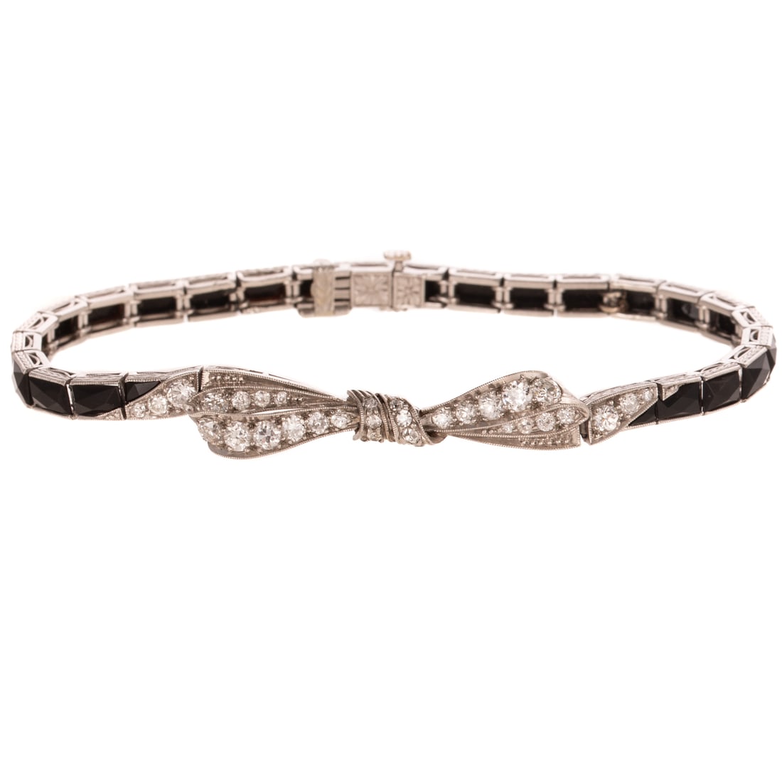 An Art Deco Diamond & Onyx Bow Bracelet in Platinum: c.1910s, platinum line bracelet featuring diamonds weighing approx. 1.00 ctw with an average color grade of I - J and an average clarity grade of VS bead set into central bow with milgrain accent, cha